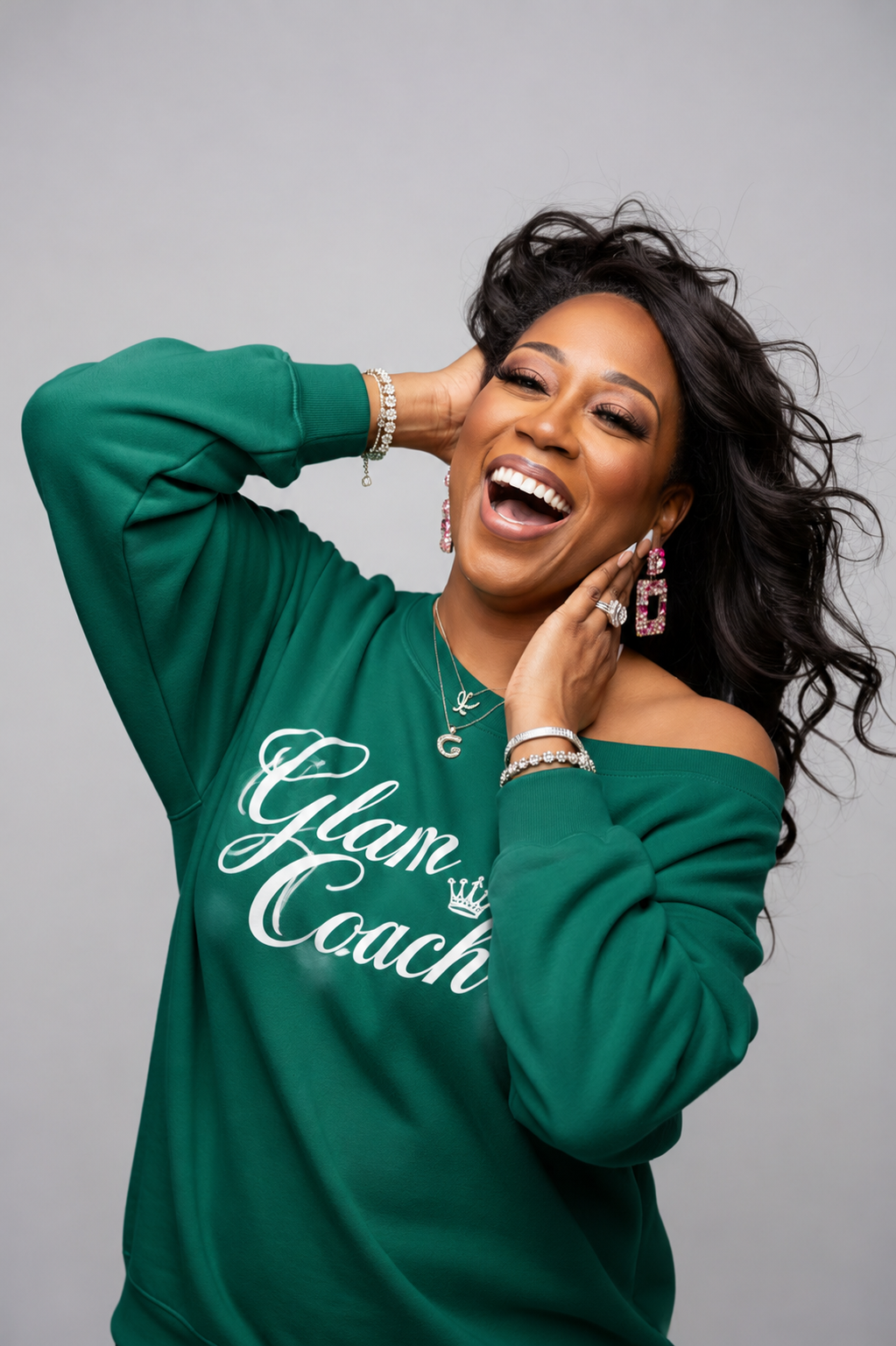 Founder of The Glam Coach™, wearing a signature emerald Glam Coach sweatshirt.
